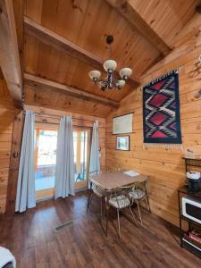a dining room with a table in a log cabin at Cozy Forest Cabin with Hot Tub in Central Flagstaff in Flagstaff