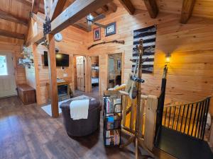 a living room in a cabin with wooden walls at Cozy Forest Cabin with Hot Tub in Central Flagstaff in Flagstaff