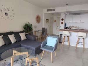 a living room with a blue couch and a kitchen at Beautiful Sea View Home Overlooking Monaco in Beausoleil