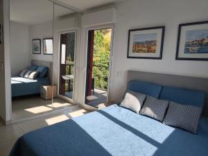 a bedroom with a blue bed and a mirror at Beautiful Sea View Home Overlooking Monaco in Beausoleil +75 photos