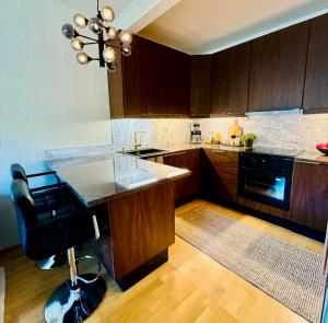 a kitchen with wooden cabinets and a black appliance at Nordic Retreat Quiet Oasis in Oslo in Oslo