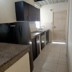 a kitchen with black cabinets and a stove top oven at El delfín Santa Elena -Salinas in Santa Elena