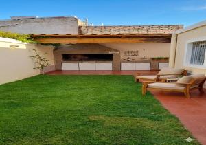 a backyard with a green lawn and a house at Casa Premium con Cochera en Mendoza Ideal Familias Hasta 7 pers in Mendoza