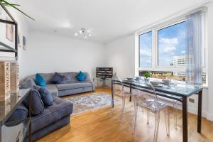 a living room with a table and a couch at Modern 2 Bed Flat 5 mins Ealing Broadway Station in Ealing