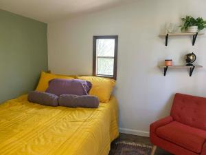 a bedroom with a yellow bed and a red chair at Swift Hollow Timeless Memories in Mountain City