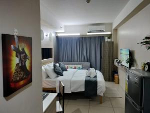 a hotel room with a bed and a television at Estor Staycation in Manila