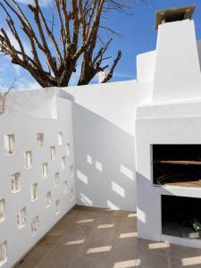 a fireplace in a white wall with a tree in the background at Alojamiento Uruguay in Santa Rosa