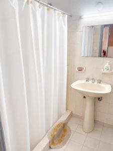 a bathroom with a white shower curtain and a sink at Alojamiento Uruguay in Santa Rosa