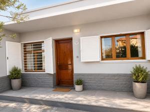 a house with a wooden door and windows at Alojamiento Uruguay in Santa Rosa