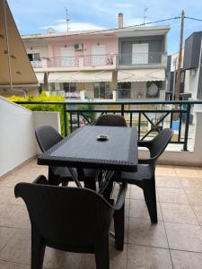 a black table and chairs on a balcony at Modern home in Kallithea Halkidikis