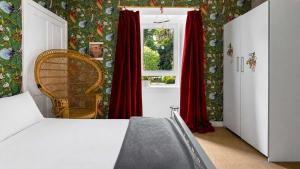 a bedroom with red curtains and a window at Williams Haven in Rothesay