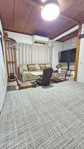 a living room with a bed and a couch at YAHouse in Chiba