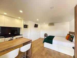 a small bedroom with a bed and a kitchen at Ribeira do Forno 2 in Adaúfe