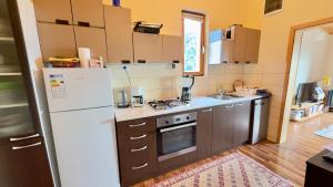 a kitchen with a white refrigerator and a sink at Prespa Lakeview Villa in Resen