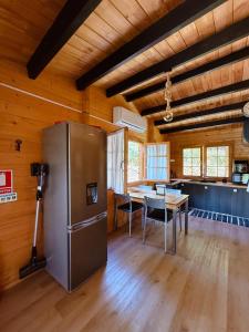 a kitchen with a stainless steel refrigerator and a table at Ohana Gerês House in Ruivãis