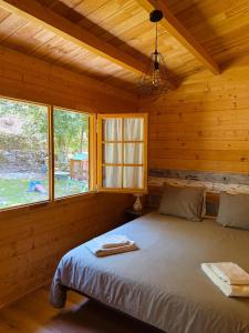 a bedroom with a bed in a log cabin at Ohana Gerês House in Ruivãis +41 photos