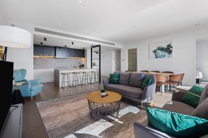 a living room with a couch and a table at The Eminence Apartments by CLLIX in Melbourne