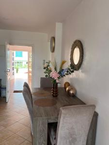 a dining room with a table with a vase of flowers at Smirpark appartement in M'diq