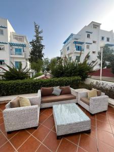 a patio with two couches and a coffee table at Smirpark appartement in M'diq