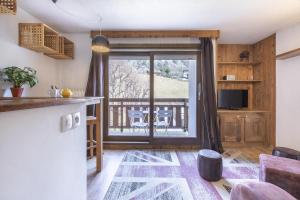 a kitchen with a sliding glass door to a deck at Résidence Hôtel Rent - Megève in Megève