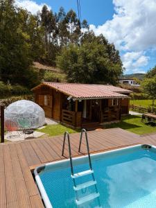 a swimming pool on a deck with a house at Ohana Gerês House in Ruivãis