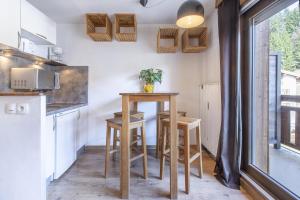 a small kitchen with a small table and chairs at Résidence Hôtel Rent - Megève in Megève +63 photos
