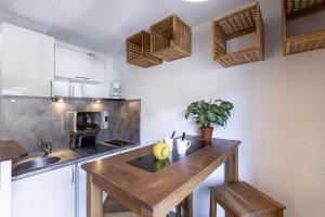 a kitchen with a wooden table in a room at Résidence Hôtel Rent - Megève in Megève