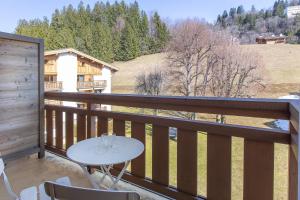 a patio with a table and chairs on a balcony at Résidence Hôtel Rent - Megève in Megève