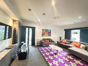 a living room with a couch and a table at La Maison Barwon in Connewarre
