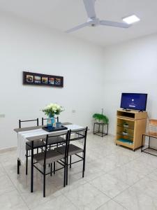 a living room with a table and chairs and a tv at GuestHouse Encanto del Centro 4 in Encarnación