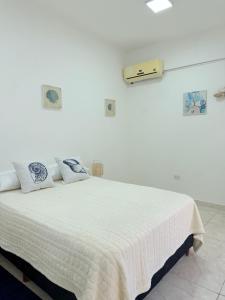 a white bedroom with a bed with a white blanket at GuestHouse Encanto del Centro 4 in Encarnación
