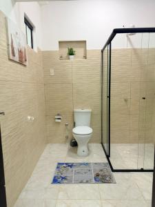 a bathroom with a toilet and a glass shower at GuestHouse Encanto del Centro 4 in Encarnación