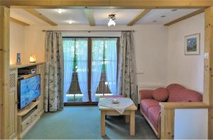 ein Wohnzimmer mit Sofa und Fernseher in der Unterkunft Haus Frechen in Berchtesgaden