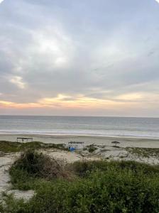 two picnic tables on a beach near the ocean at Las tortugas bungalow in Vichayito +3 photos