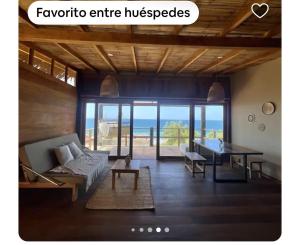 a living room with a couch and a table at Las tortugas bungalow in Vichayito