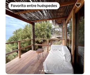 a bed on a deck with a table and a chair at Las tortugas bungalow in Vichayito