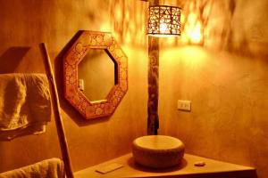 a bathroom with a mirror and a table with a lamp at Las tortugas bungalow in Vichayito