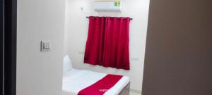 a bedroom with a red curtain and a bed with a red blanket at Twin Tag Residency in Chennai +3 photos