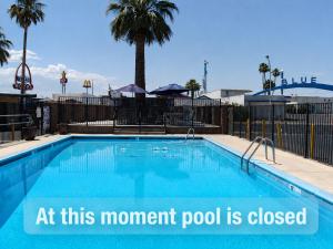 a swimming pool with a sign that reads at this moment pool is closed at Desert Hills Motel in Las Vegas