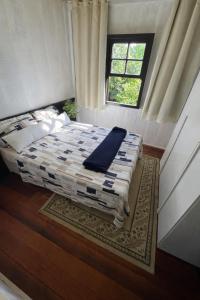 a bedroom with a bed with a blue blanket on it at Casa Centenária com 20 min de Gramado in Três Coroas