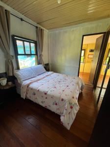 a bedroom with a bed in a room with a window at Casa Centenária com 20 min de Gramado in Três Coroas