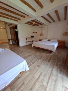 a bedroom with two beds and a wooden floor at Boana hotel in Palomino