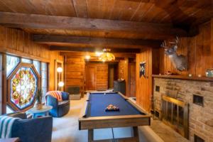 a living room with a pool table and a fireplace at The Woodsman Lodge in Eureka Springs