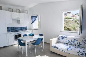 a kitchen and living room with a table and a couch at Costa Paradiso Sea View - 8 Guests in Trinità d'Agultu e Vignola