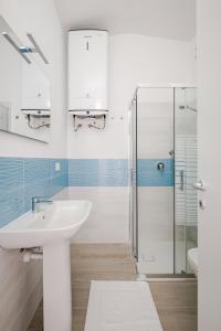 a white bathroom with a sink and a shower at Costa Paradiso Sea View - 8 Guests in Trinità d'Agultu e Vignola