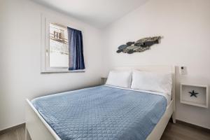 a bedroom with a bed with a blue comforter at Costa Paradiso Sea View - 8 Guests in Trinità d'Agultu e Vignola