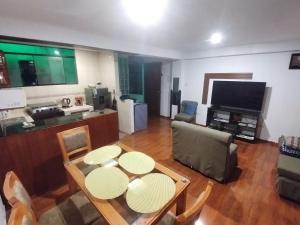 a living room with a table and chairs and a television at Cusco Tahuanwasi Apartments in Cusco