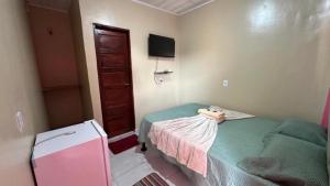 a small room with a bed and a tv at Pousada recanto da fronteira in Oiapoque