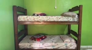 two bunk beds in a room with a green wall at Pousada recanto da fronteira in Oiapoque +1 photo