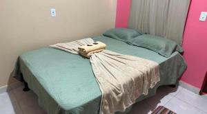 a bedroom with a bed with a bag on it at Pousada recanto da fronteira in Oiapoque